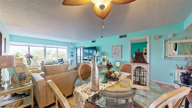 dining area featuring a textured ceiling, baseboards, visible vents, and a ceiling fan