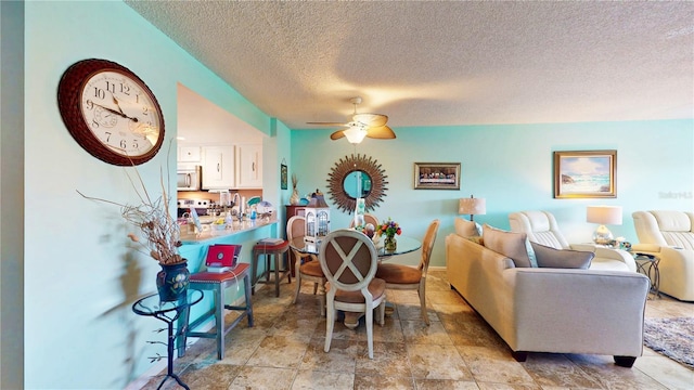 interior space with a textured ceiling and a ceiling fan