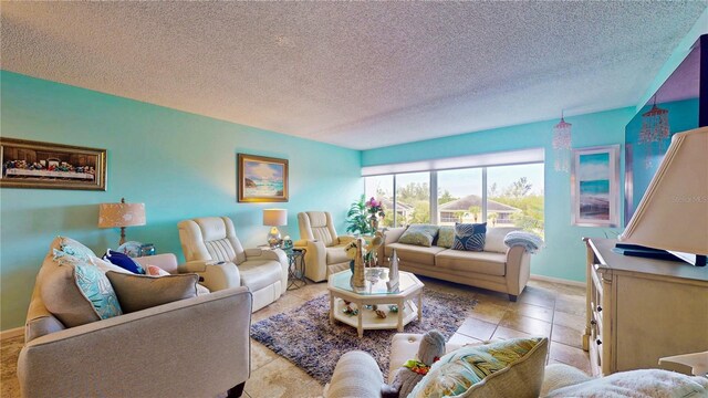 living room with light tile patterned floors, a textured ceiling, and baseboards