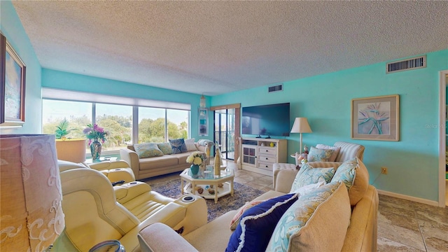 living room featuring visible vents, a textured ceiling, and baseboards