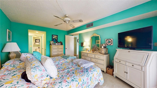 bedroom featuring light colored carpet, visible vents, ceiling fan, and a textured ceiling