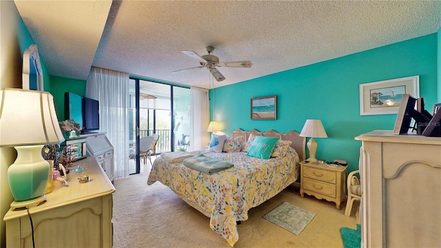 carpeted bedroom featuring access to exterior, floor to ceiling windows, a textured ceiling, and a ceiling fan