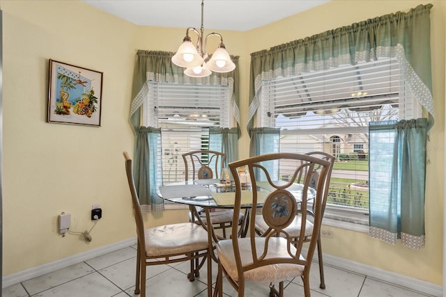 tiled dining area featuring baseboards and an inviting chandelier