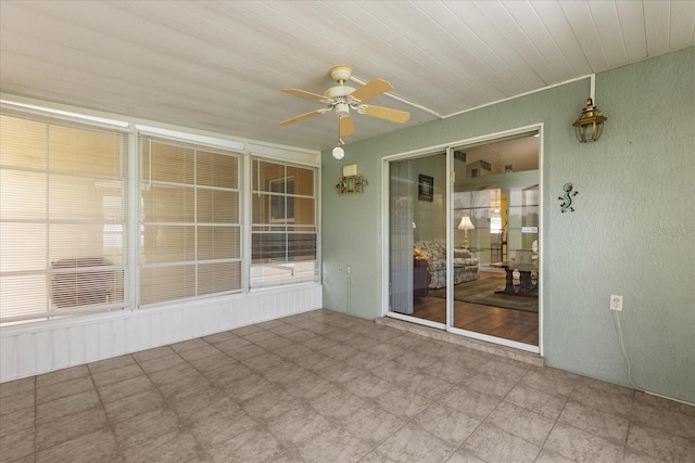 unfurnished sunroom with ceiling fan