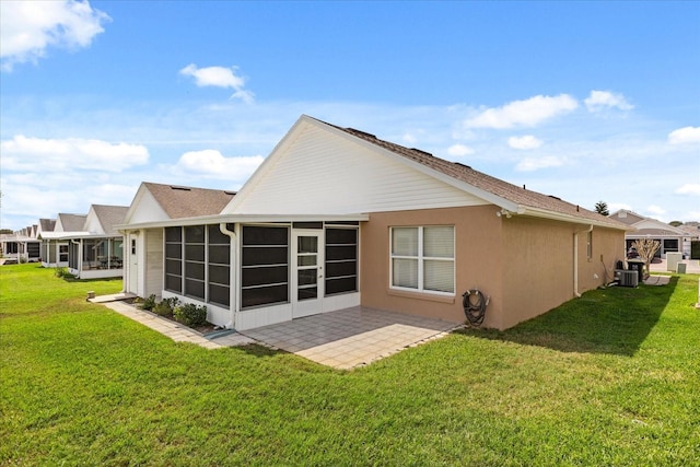 rear view of house featuring central AC, a sunroom, a lawn, stucco siding, and a patio area