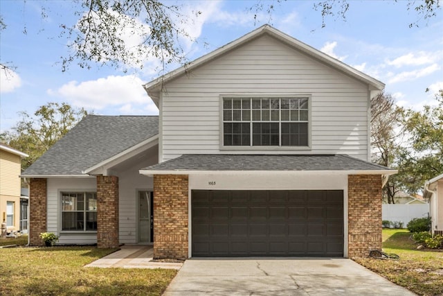 traditional-style house with concrete driveway, brick siding, a shingled roof, and a front yard