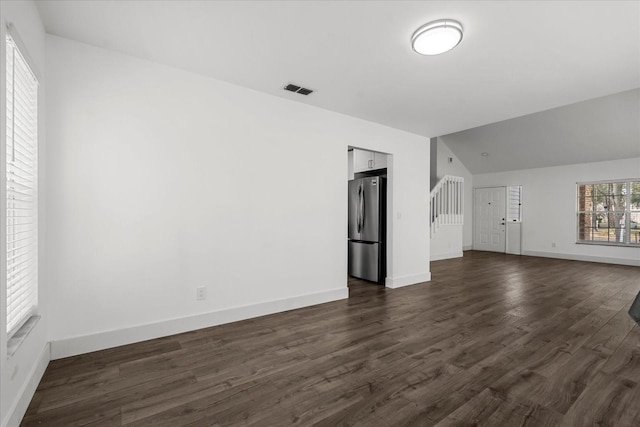 unfurnished living room featuring lofted ceiling, visible vents, dark wood finished floors, and baseboards