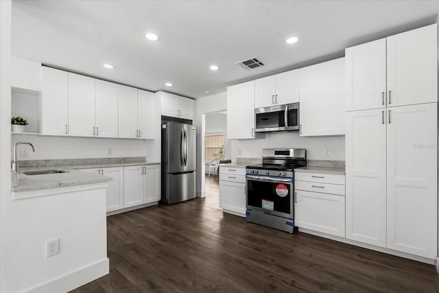 kitchen with dark wood finished floors, open shelves, visible vents, appliances with stainless steel finishes, and a sink