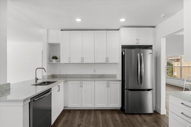 kitchen with stainless steel appliances, a sink, white cabinetry, light stone countertops, and open shelves