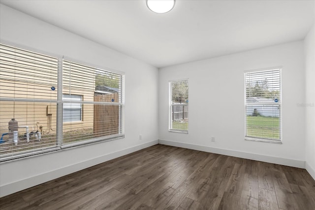 unfurnished room featuring dark wood-style floors and baseboards