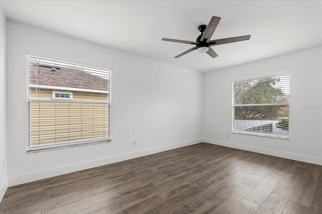 unfurnished room with dark wood-type flooring, ceiling fan, and baseboards