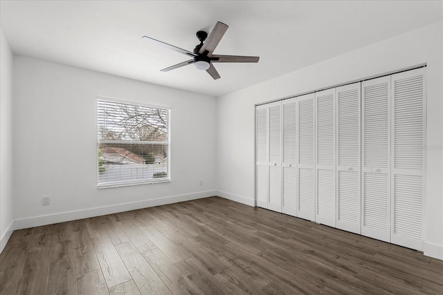 unfurnished bedroom featuring a closet, ceiling fan, baseboards, and wood finished floors