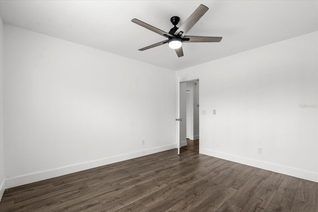 spare room featuring dark wood-style floors, ceiling fan, and baseboards