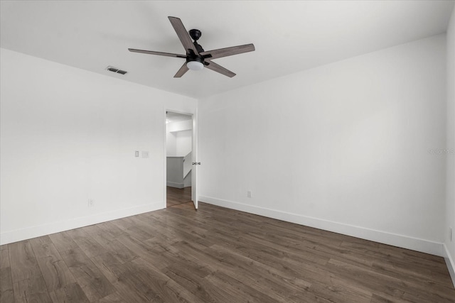 unfurnished room featuring a ceiling fan, dark wood-style flooring, visible vents, and baseboards