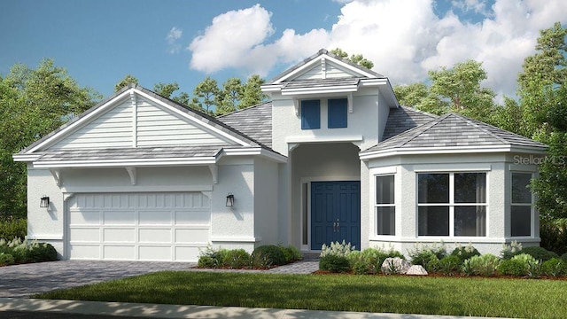 view of front of home with a garage, decorative driveway, a front lawn, and stucco siding