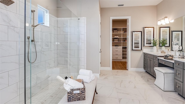 bathroom featuring marble finish floor, walk in shower, vanity, and baseboards