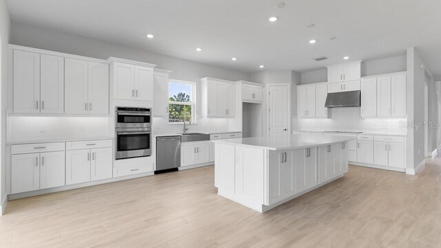 5641 Nevis Ter, Kissimmee, FL 34758 - kitchen featuring appliances with stainless steel finishes, under cabinet range hood, a sink, decorative backsplash, and recessed lighting