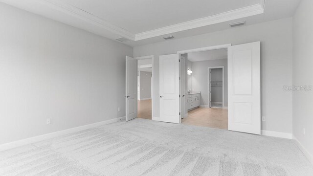 5641 Nevis Ter, Kissimmee, FL 34758 - unfurnished bedroom featuring light carpet, crown molding, baseboards, and a raised ceiling