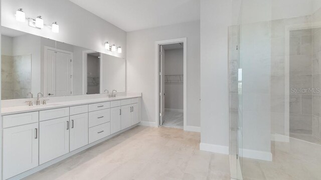 5641 Nevis Ter, Kissimmee, FL 34758 - full bathroom with double vanity, a spacious closet, tiled shower, and baseboards