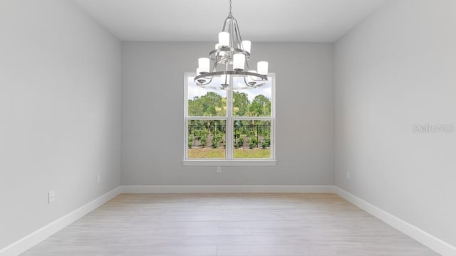 5641 Nevis Ter, Kissimmee, FL 34758 - empty room featuring a chandelier, light wood-style floors, and baseboards