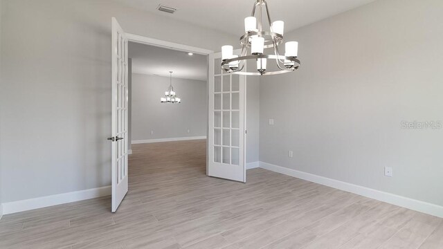 5641 Nevis Ter, Kissimmee, FL 34758 - empty room featuring a chandelier, french doors, baseboards, and light wood-type flooring