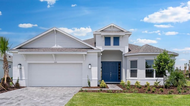 5641 Nevis Ter, Kissimmee, FL 34758 - view of front of house featuring roof with shingles, stucco siding, decorative driveway, and a garage