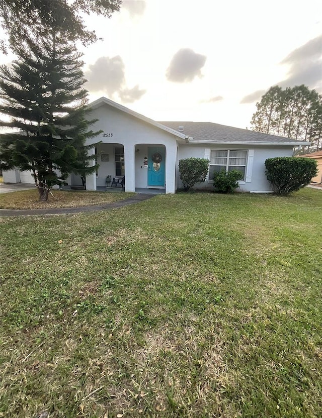 view of front of house with a front yard and stucco siding