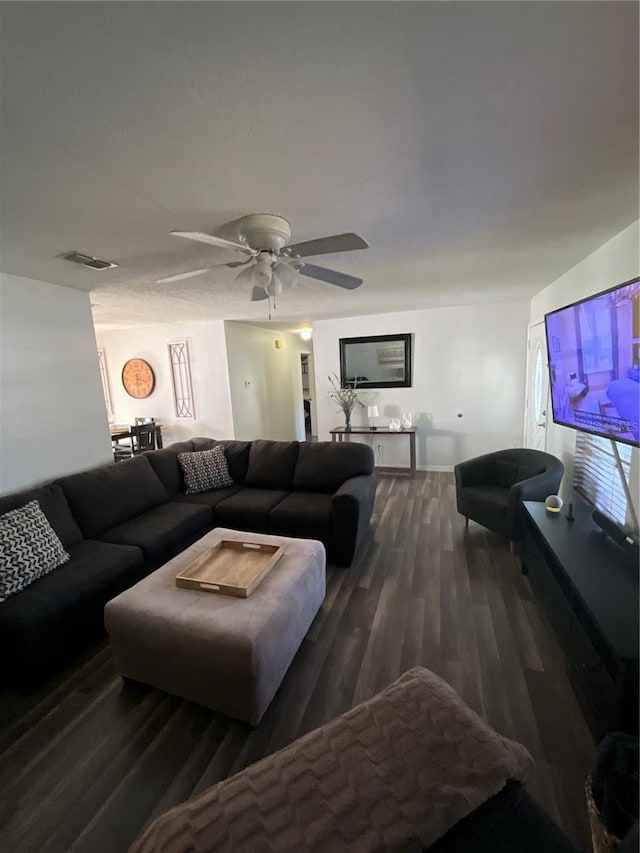 living room with a ceiling fan, visible vents, and wood finished floors