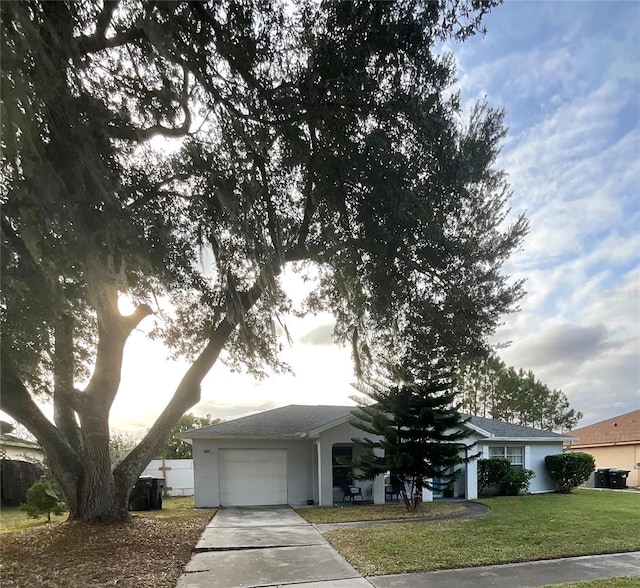 view of front of house featuring a garage, driveway, central AC unit, and a front yard