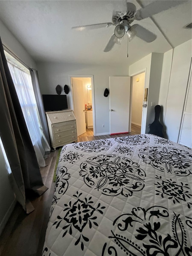 bedroom with visible vents, ceiling fan, ensuite bath, and wood finished floors