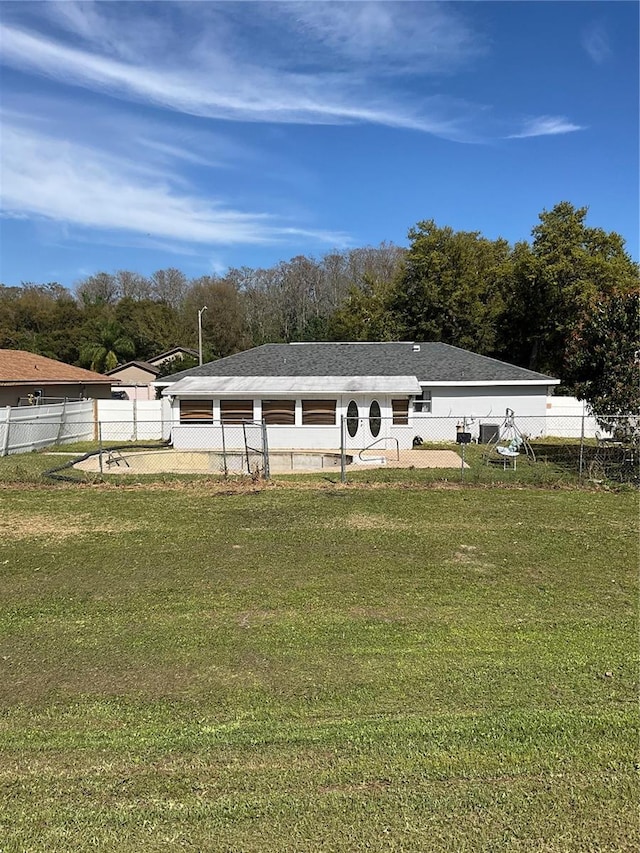 back of property featuring a fenced backyard and a lawn