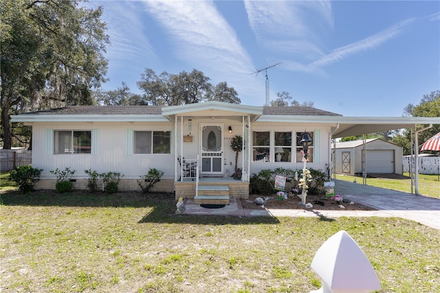 view of front of house with an outbuilding, an attached carport, driveway, crawl space, and a front lawn