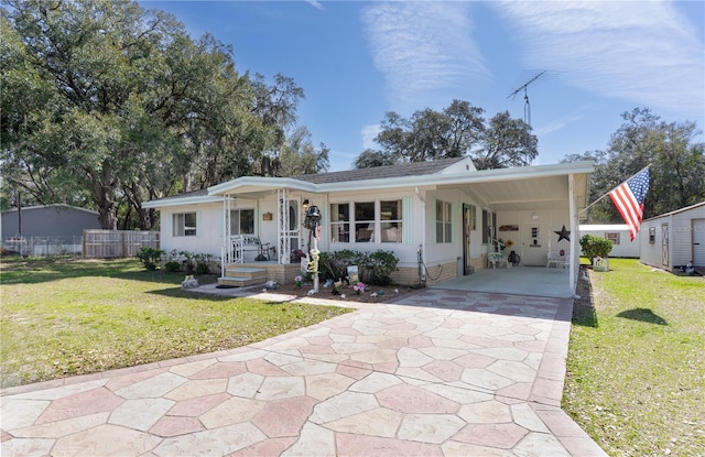 view of front of home featuring a carport, a front lawn, concrete driveway, and fence