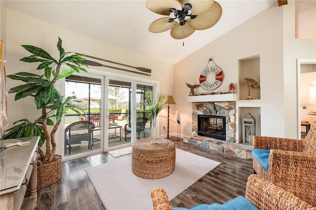 living area with ceiling fan, high vaulted ceiling, a fireplace, and wood finished floors