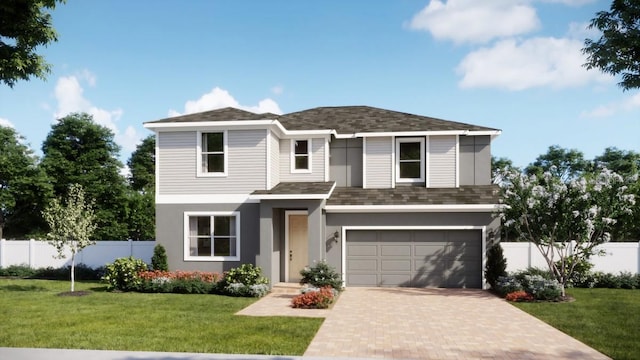 view of front of home featuring a garage, decorative driveway, a front yard, and fence