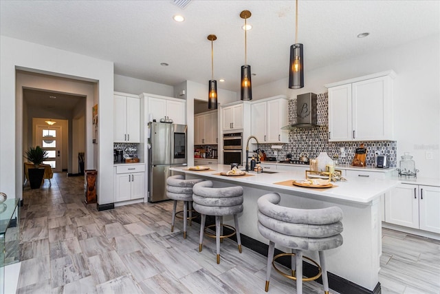 15724 Cutter Sail Pl, Winter Garden, FL 34787 - kitchen featuring a breakfast bar, a sink, light countertops, appliances with stainless steel finishes, and wall chimney range hood