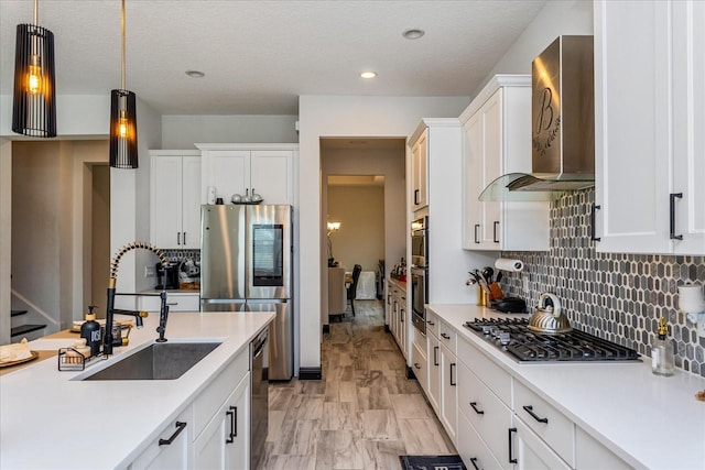 15724 Cutter Sail Pl, Winter Garden, FL 34787 - kitchen with wall chimney exhaust hood, appliances with stainless steel finishes, decorative light fixtures, light countertops, and a sink