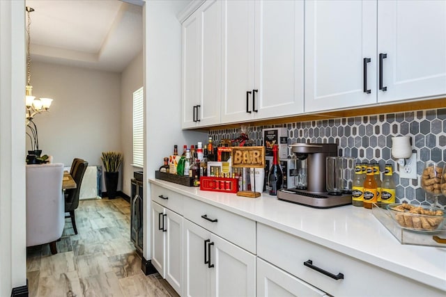 15724 Cutter Sail Pl, Winter Garden, FL 34787 - kitchen with tasteful backsplash, light countertops, a notable chandelier, and white cabinetry