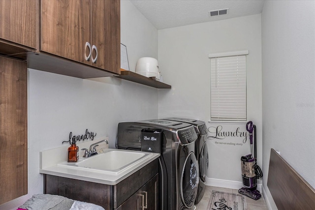 15724 Cutter Sail Pl, Winter Garden, FL 34787 - clothes washing area with cabinet space, visible vents, a textured ceiling, washing machine and dryer, and a sink