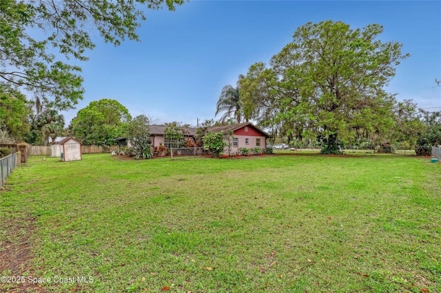 view of yard featuring an outbuilding, a storage unit, and a fenced backyard