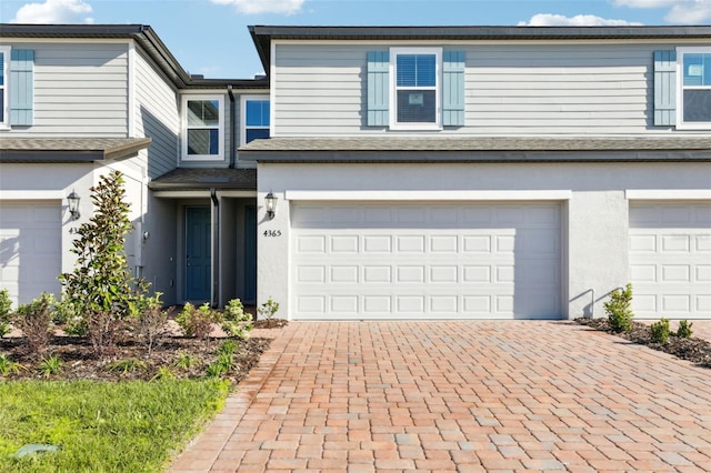 4365 Switchgrass Ln, Saint Cloud, FL 34772 - view of front of home featuring stucco siding, decorative driveway, and an attached garage