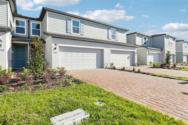 4365 Switchgrass Ln, Saint Cloud, FL 34772 - view of front of property with an attached garage, stucco siding, and decorative driveway