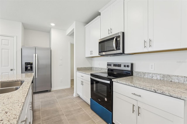 4365 Switchgrass Ln, Saint Cloud, FL 34772 - kitchen with light stone countertops, white cabinetry, recessed lighting, appliances with stainless steel finishes, and light tile patterned flooring