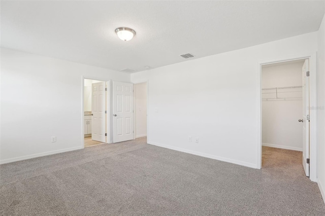 4365 Switchgrass Ln, Saint Cloud, FL 34772 - unfurnished bedroom featuring a walk in closet, visible vents, baseboards, and carpet