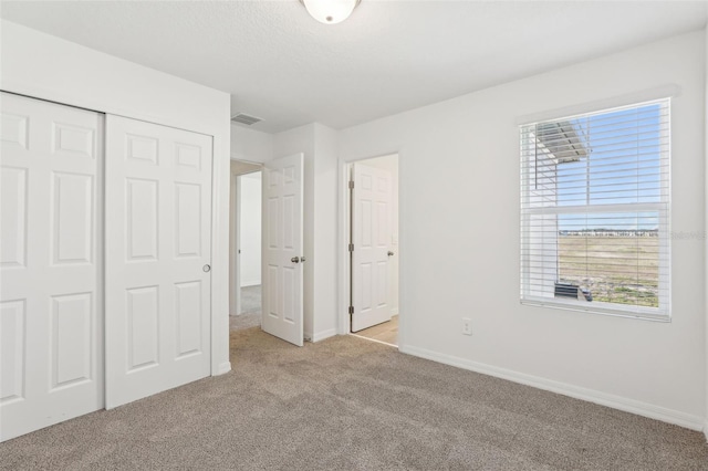 4365 Switchgrass Ln, Saint Cloud, FL 34772 - unfurnished bedroom featuring light carpet, a closet, baseboards, and visible vents