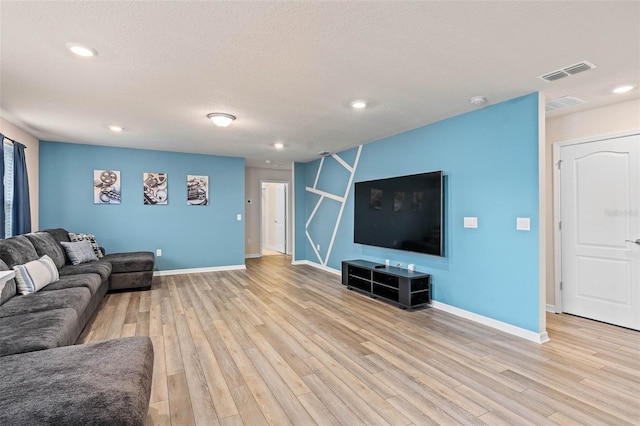 living area featuring light wood-type flooring, baseboards, and visible vents