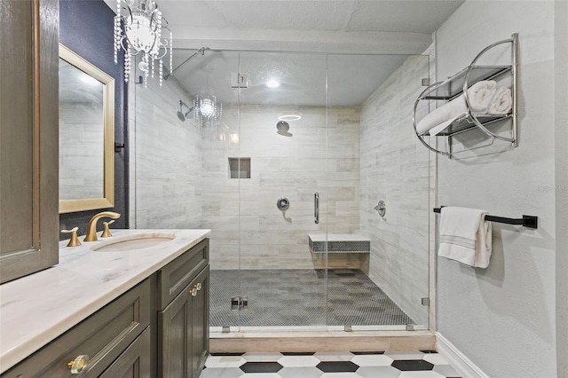 bathroom featuring tile patterned floors, a shower stall, vanity, and baseboards