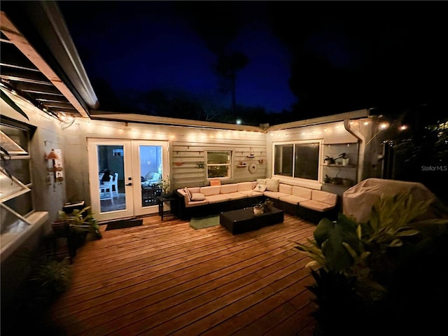 deck at night featuring french doors and outdoor lounge area