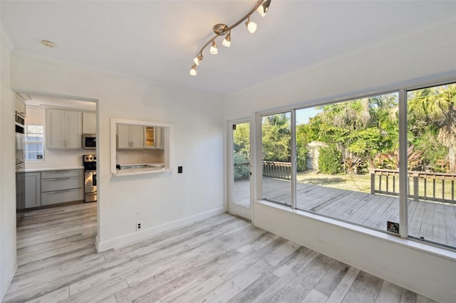 interior space with light wood-type flooring, plenty of natural light, and baseboards