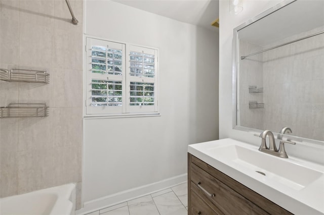 full bath with marble finish floor,  shower combination, vanity, and baseboards